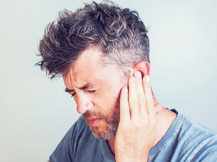 Hearing care help and advice dealing with Tinnitus is available across Devon and Cornwall at Peninsula Hearing Care - here a patient is holding his ear because it is ringing